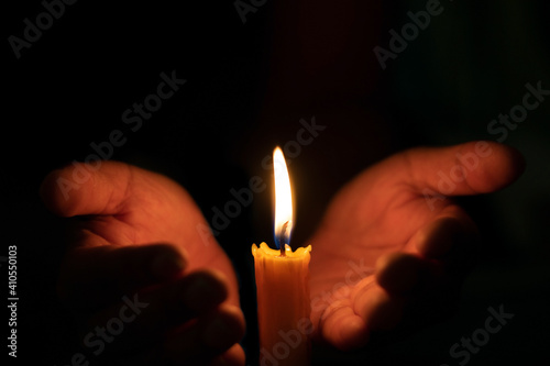 Holding a burning candle in the night