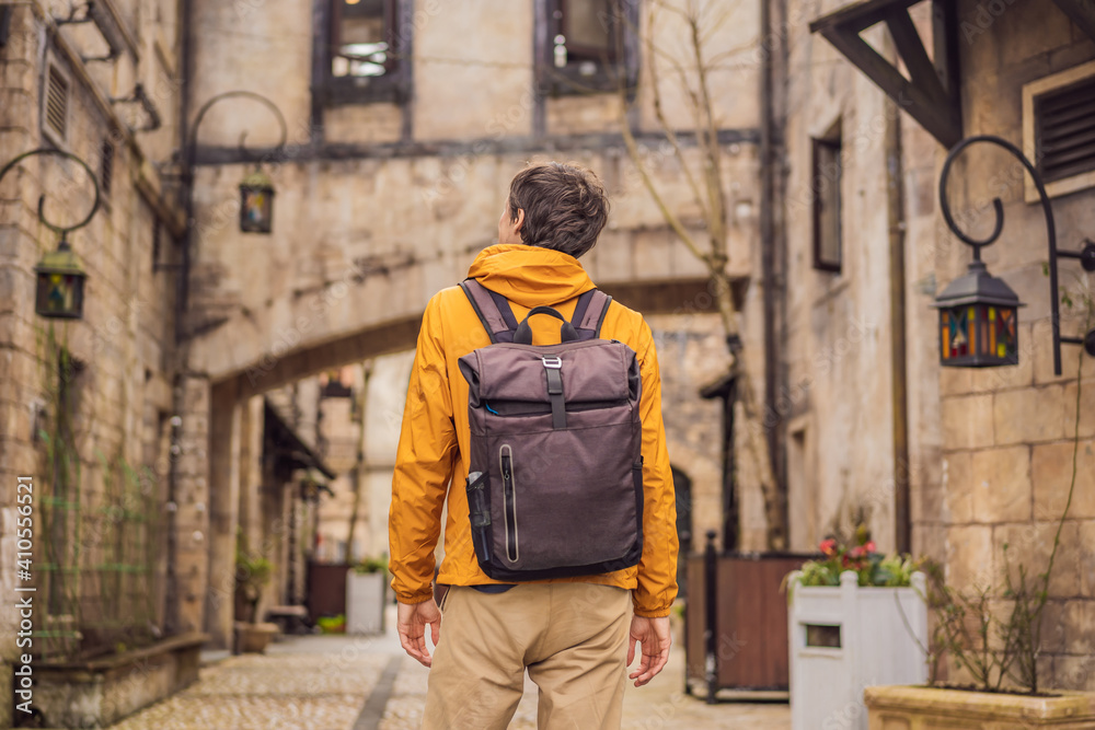 Fototapeta premium Young man tourist walks down the street in a European city after the end of COVID-19 coronavirus. quarantine is over