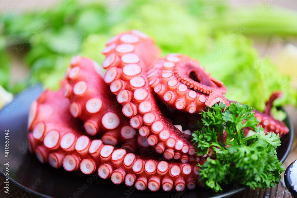 Fresh octopus food on black plate, cooked squid salad vegetable seafood cuttlefish dinner restaurant, Boiled octopus tentacles. Fresh octopus food on black plate, cooked squid salad vegetable seafood cuttlefish dinner restaurant, Boiled octopus tentacles.