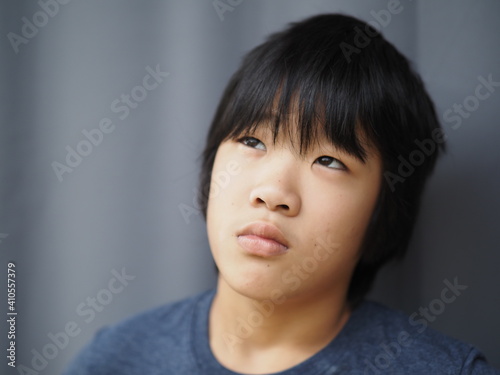 Funny portrait of 11 years old asian boy with dark blue t shirt 