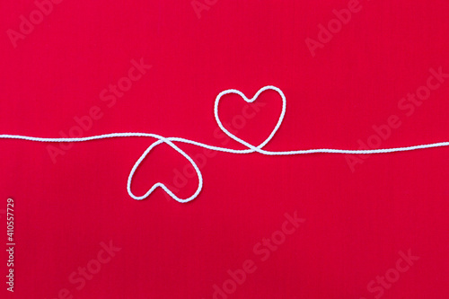 White heart on red fabric background, love and romance concept, valentine card background idea, white thread arrange in heart shape on red background