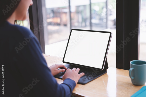 Side View shot of young business woman working with mockup white screen laptop computer at cafe. clipping path