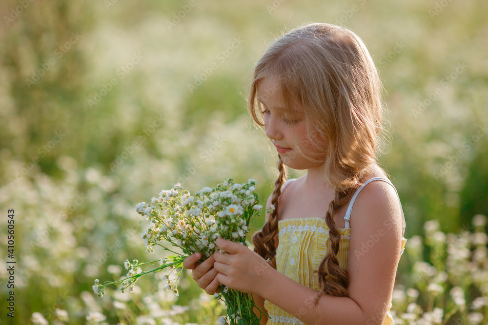 portrait of a little girl holding a bouquet in a field in summer portrait of a little girl holding a bouquet in a field in summer