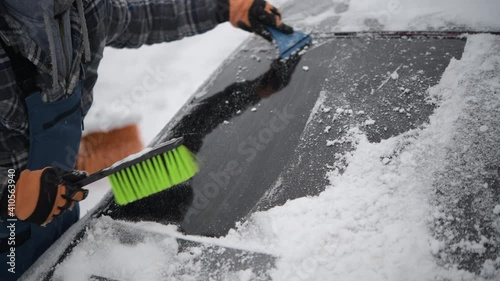 Snow Removal From Car. Men Cleaning Car From the Snow. photo