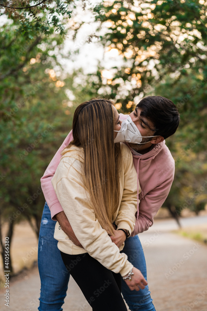 Fototapeta premium couple kissing with masks, happy latin couple