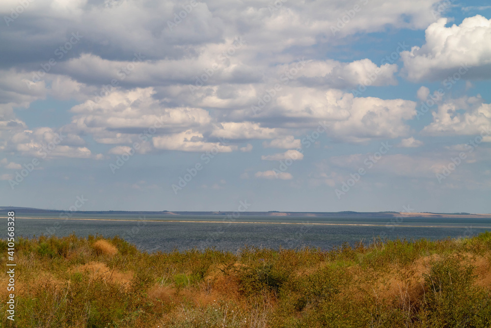 View of the blue sea from the steppe with yellow grass in the south of Russia