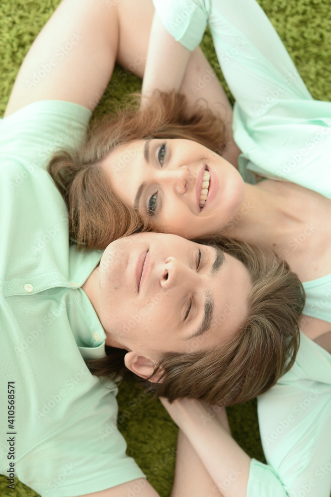 Portrait of happy young couple in love lying on floor at home Portrait of happy young couple in love lying on floor at home