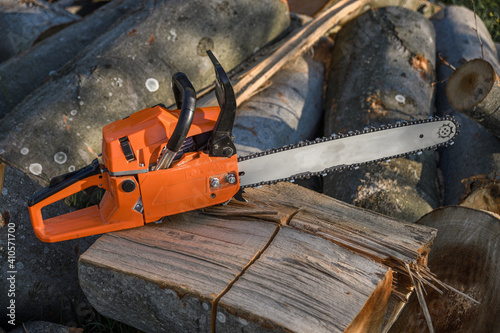 Wallpaper Mural Chainsaw that stands on a heap of firewood in the yard on a background of firewood and trees cut by a chainsaw Torontodigital.ca