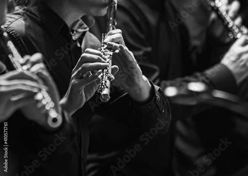 Hands of a musician playing the flute in an orchestra in black and white