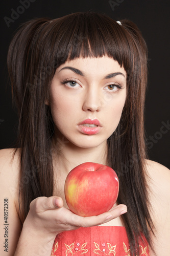 Portrait of beautiful young woman with apple