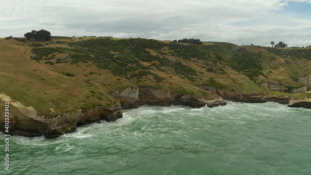Aerial shot of cliffs during the day along the coastline in New Zealand Aerial shot of cliffs during the day along the coastline in New Zealand