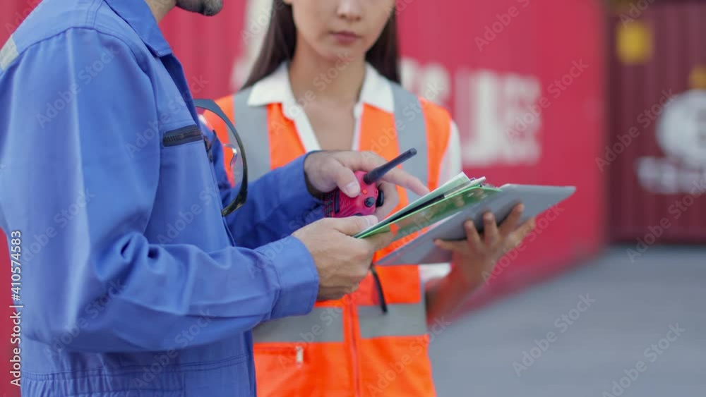 Two engineer male and female worker dockers in checking examine discussion, in front of a large industrial harbor,Engineer or foreman or worker checking and talking together shipyard Job concept Two engineer male and female worker dockers in checking examine discussion, in front of a large industrial harbor,Engineer or foreman or worker checking and talking together shipyard Job concept