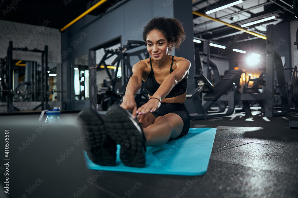 Pleased international female doing sport at gym Pleased international female doing sport at gym