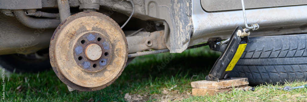 own repair of car drum brake himself. repair of broken car drum brake disassembled outdoor. banner own repair of car drum brake himself. repair of broken car drum brake disassembled outdoor. banner