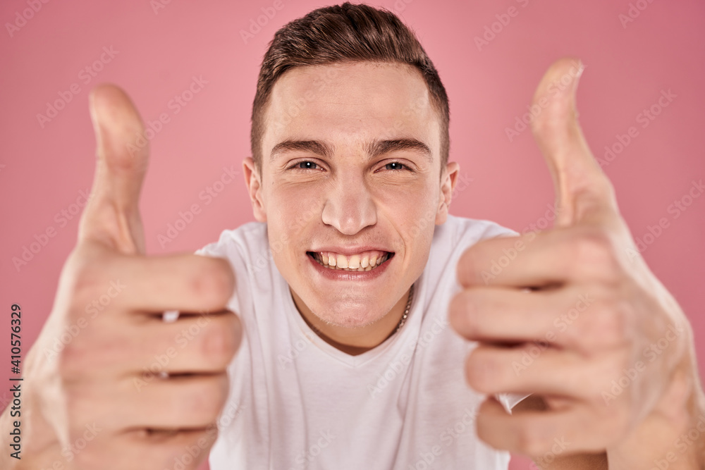 cheerful man in white t-shirt smile emotions close-up pink background studio