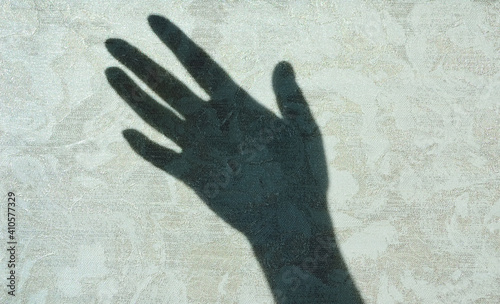 close-up - silhouette, shadow on the wall from the hand raised up