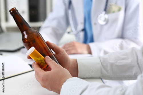 Photography Alcoholic hold in hand empty bottle at doctor reception office closeup
