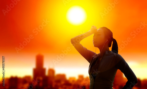 Fotografie Woman shielding her eyes from sun with summer heat wave in the city background