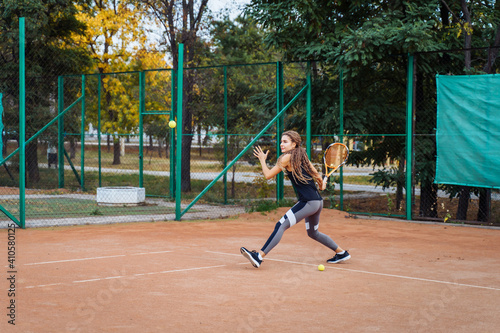 Professional equipped female tennis player beating hard the tennis ball with racquet. Its good having nice time at your favorite workout © Daria