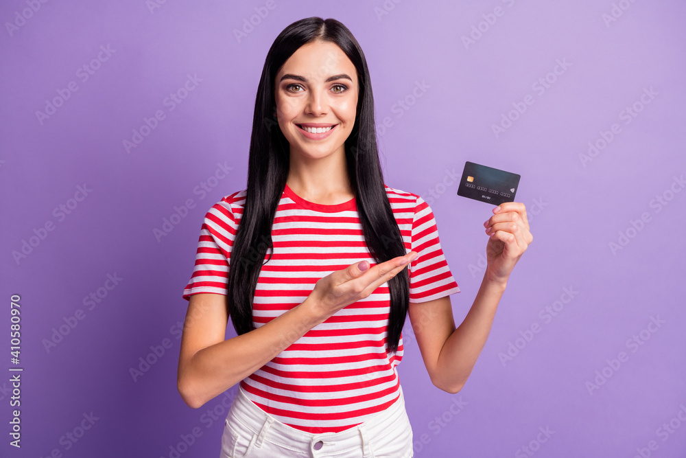 Photo of positive brunette lady point hand hold credit card offer ad product isolated on violet color background Photo of positive brunette lady point hand hold credit card offer ad product isolated on violet color background