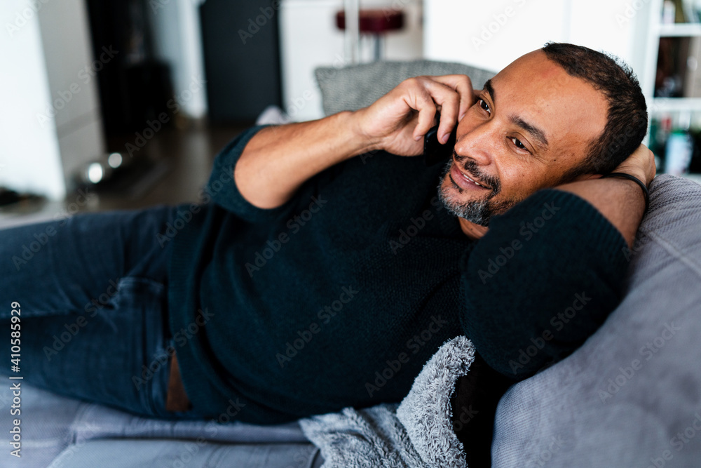 Handsome man talking on the phone at home Handsome man talking on the phone at home