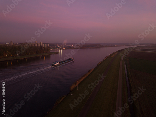 Barge boat cruising on the Ghent-Terneuzen canal, towards Terneuzen, at dawn. Aerial view  photo