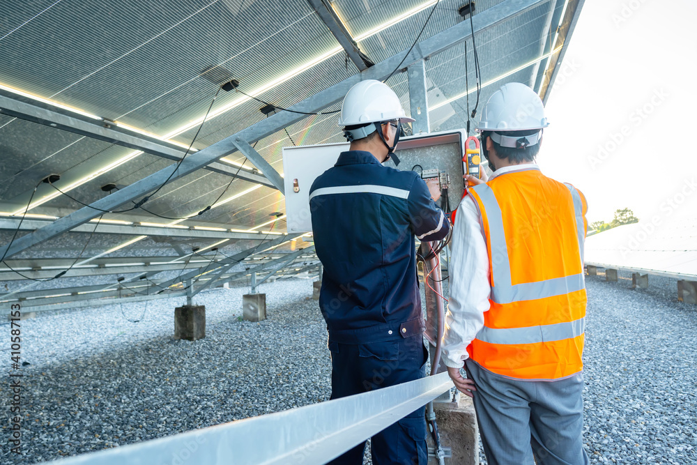 Workers use clamp meter to measure the current of electrical wires produced from solar energy for confirm to normal current