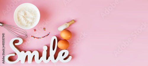 Ingredients for cooking baking - flour, egg, sugar, rolling pin on pink background. Concept of cooking dessert. banner