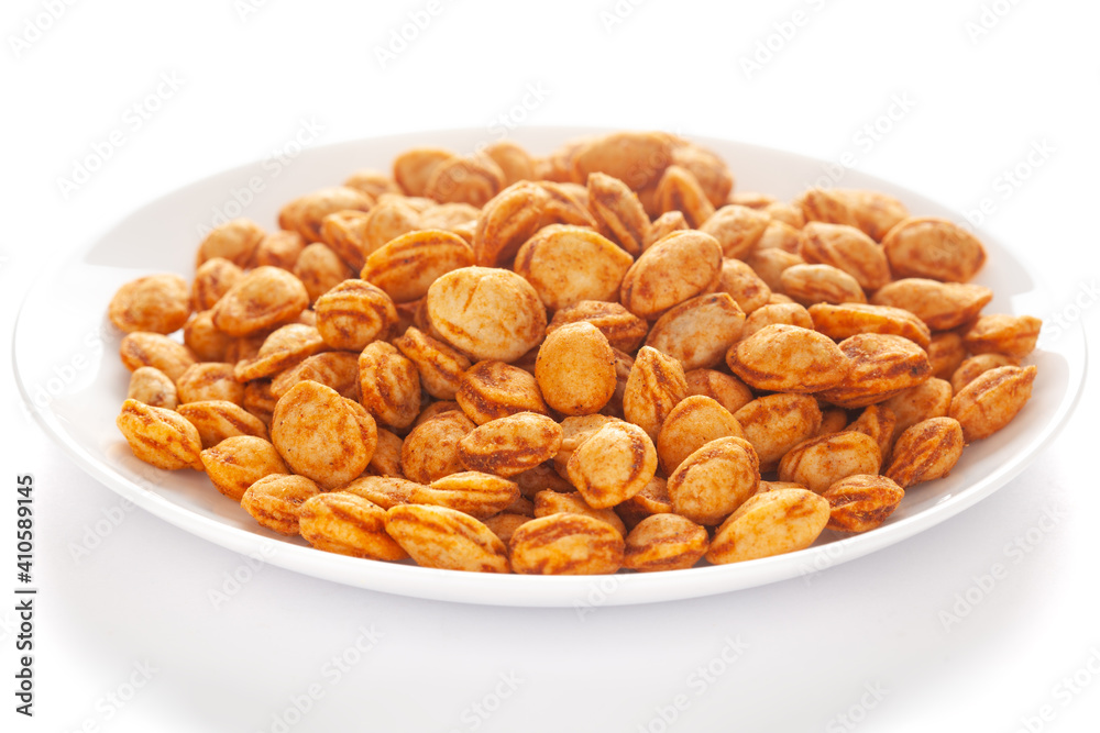 Roasted Crunchy Peanuts in a white ceramic square plate, made with peanuts. Pile of Indian spicy snacks (Namkeen), under backlight, side view Roasted Crunchy Peanuts in a white ceramic square plate, made with peanuts. Pile of Indian spicy snacks (Namkeen), under backlight, side view