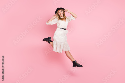 Full length photo of carefree lady jump wear retro cap dotted dress boots isolated pink color background © deagreez