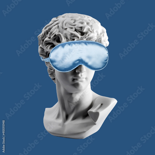 Fotografie Gypsum statue of David head in blue sleep mask