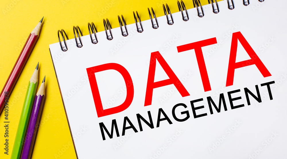 DATA MANAGEMENT on a white notepad with pencils on a yellow background. Business concept DATA MANAGEMENT on a white notepad with pencils on a yellow background. Business concept