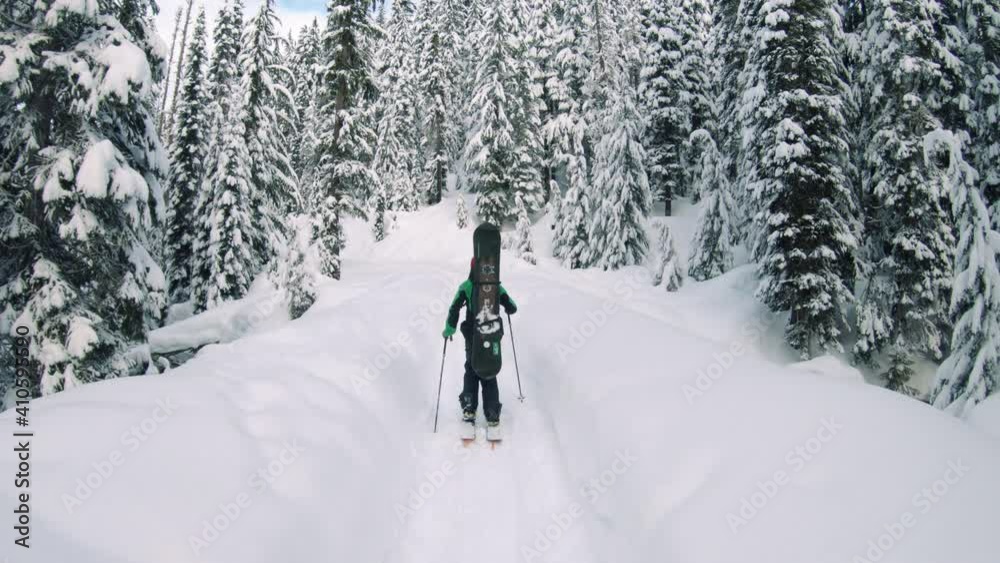 Snowy Mountain Hiking Adventure Following Man with Skis and Poles Snowy Mountain Hiking Adventure Following Man with Skis and Poles