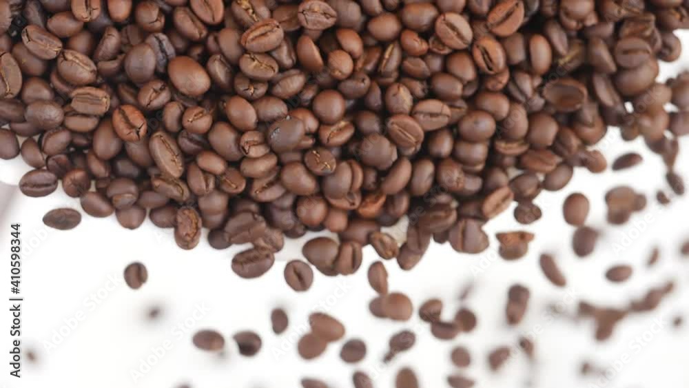Close view of dropping coffee beans over white background Close view of dropping coffee beans over white background