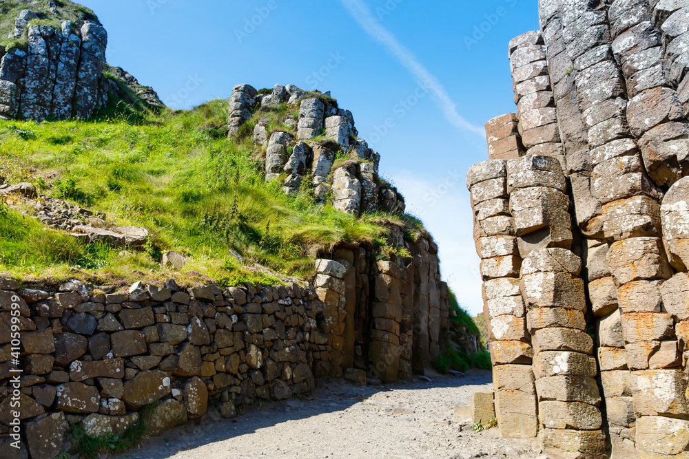 Landscape of Giant's Causeway trail with a blue sky in summer in Northern Ireland, County Antrim. UNESCO heritage. It is an area of basalt columns, the result of an ancient volcanic fissure eruption
