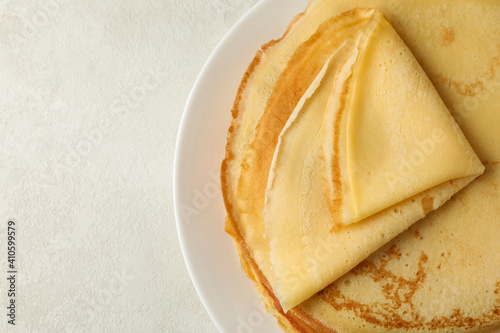 Tableau sur toile Plate with thin pancakes on white textured background