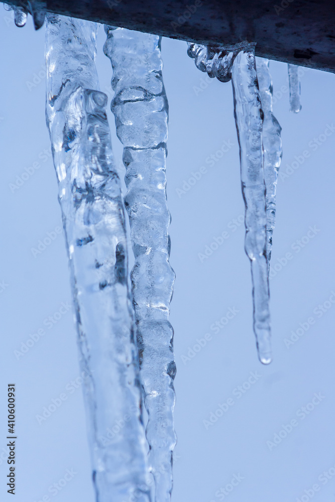 Closeup icicles background. Icicles hanging down from a roof. Cold weather, winter season