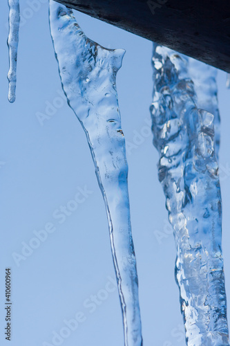 Closeup icicles background. Icicles hanging down from a roof. Cold weather, winter season