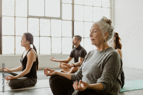 Diverse people meditating in a yoga class photo