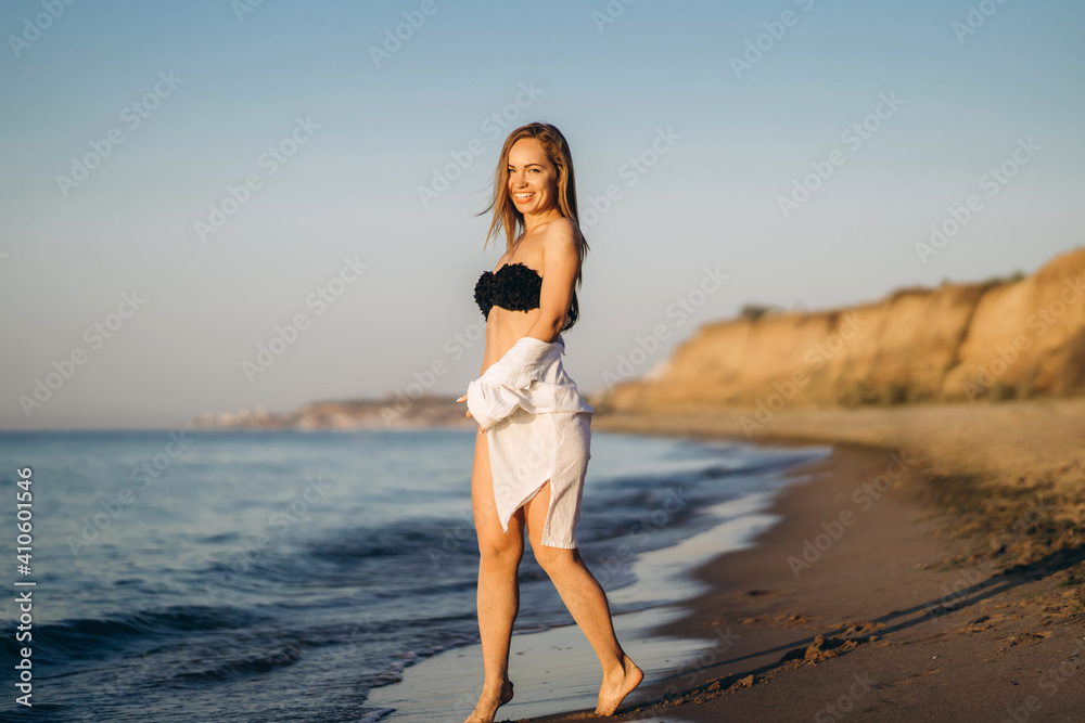 Naklejka premium Pretty brunette woman relaxing on the beach at the sea.