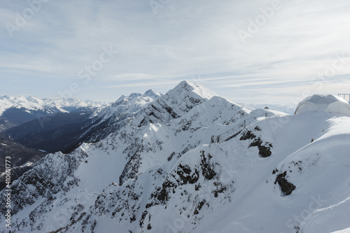 Alpine landscape, slopes of high mountains with glaciers against the blue sky.