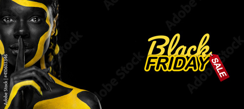 Black friday sale and shopping concept Woman with body paint. Cheerful young african girl with art bodypaint. An amazing model with yellow and black makeup. photo