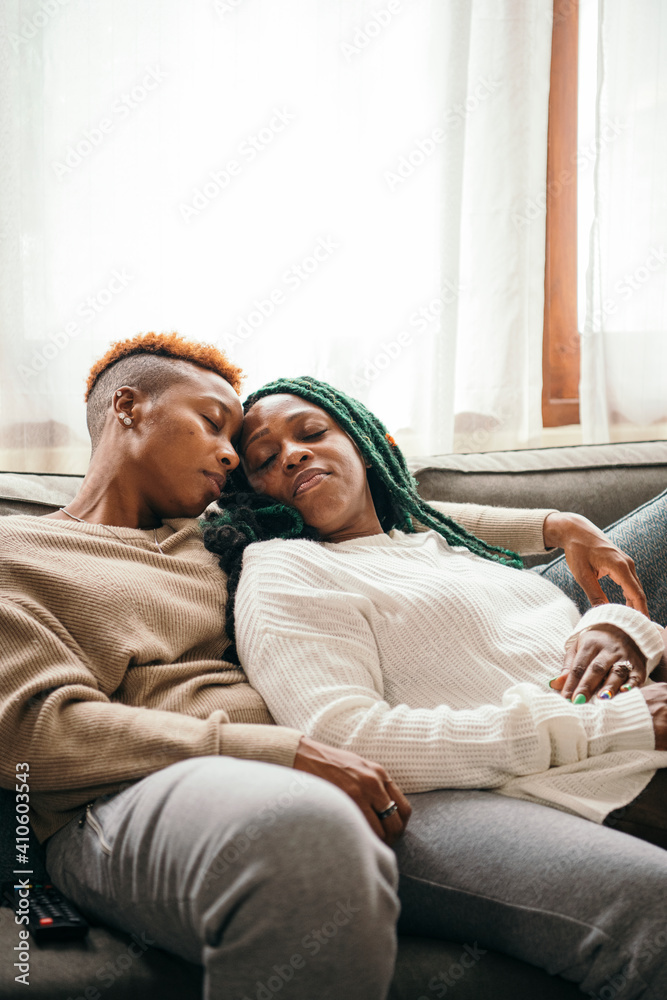 Happy lesbian couple asleep on the couch