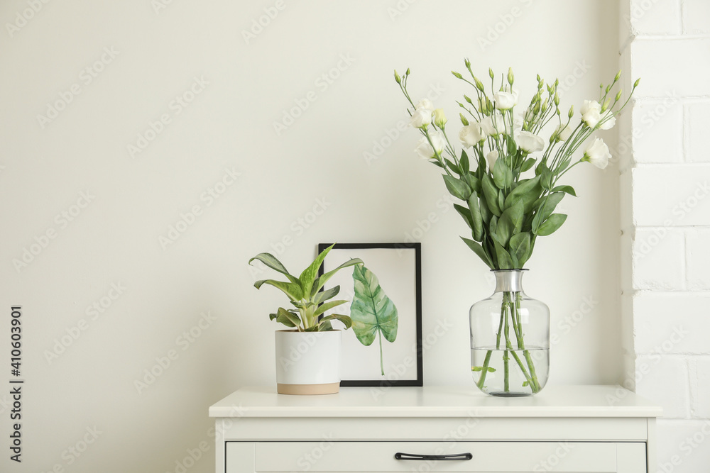 Decorative vase with flowers and houseplant on commode indoors - obrazy, fototapety, plakaty 