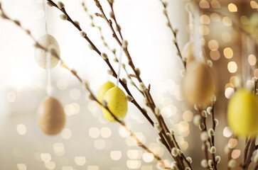 holidays and object concept - close up of pussy willow branches decorated by easter eggs over bokeh lights