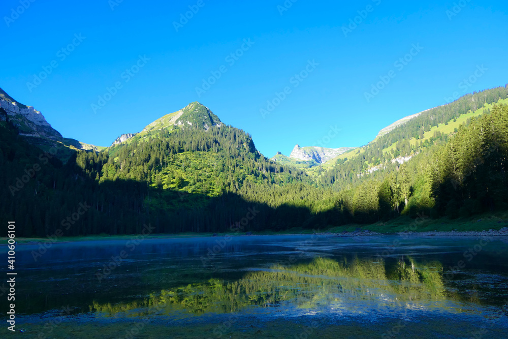 Rising haze on a foothills lake in the european forested alps in the morning sun