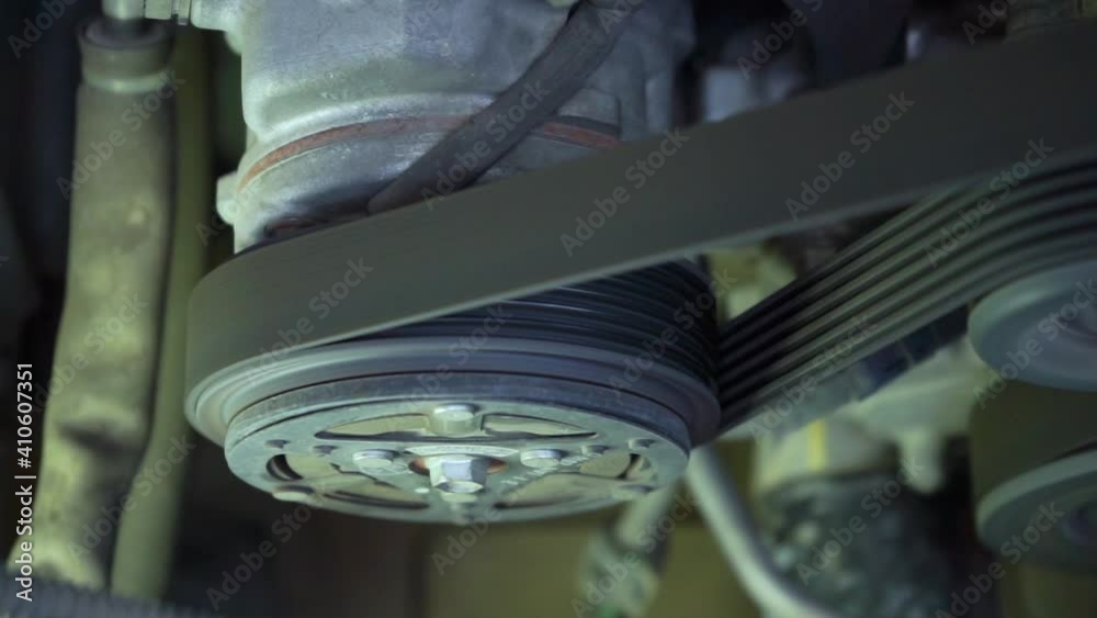 Close up detail of the engine  fragment are working by the air conditioner compressor starting runing and then stop.