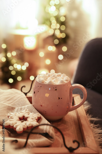 Cup of hot drink with marshmallows and cookie on wooden tray indoors. Christmas atmosphere