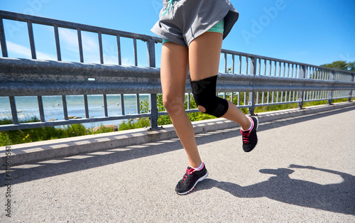 Fotografia fitness, sport and healthy lifestyle concept - feet of young woman with knee bra