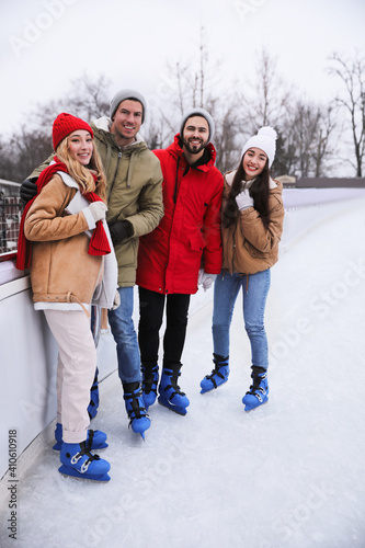 Group of friends near fence at outdoor ice rink